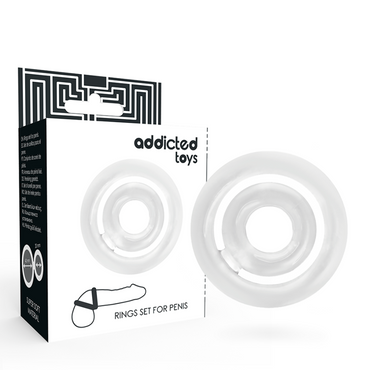 The image shows a transparent silicone penis ring set from Addicted Toys. The set includes two rings of different sizes, and the packaging features a geometric black and white design.