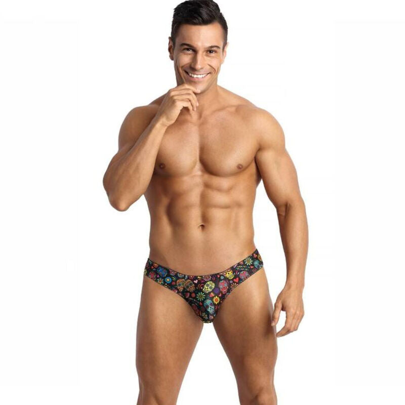 This image features a model wearing the Anais Men - Mexico String L, a stylish and comfortable men's thong designed with a unique aesthetic. The thong boasts a soft modal fabric and comes in a clear color adorned with a playful print of small flowers and a skull, adding a touch of edginess.